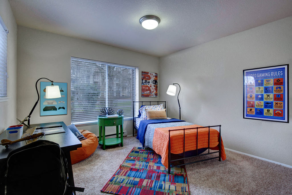 a bedroom with a bed and a desk and a window