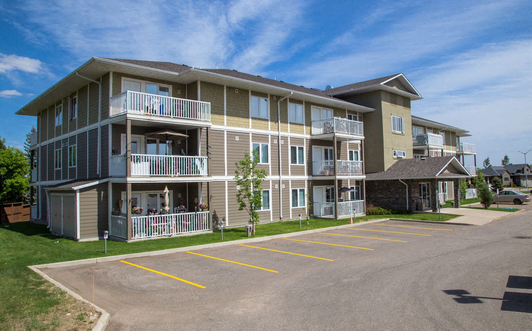 a large apartment building with balconies and a parking lot