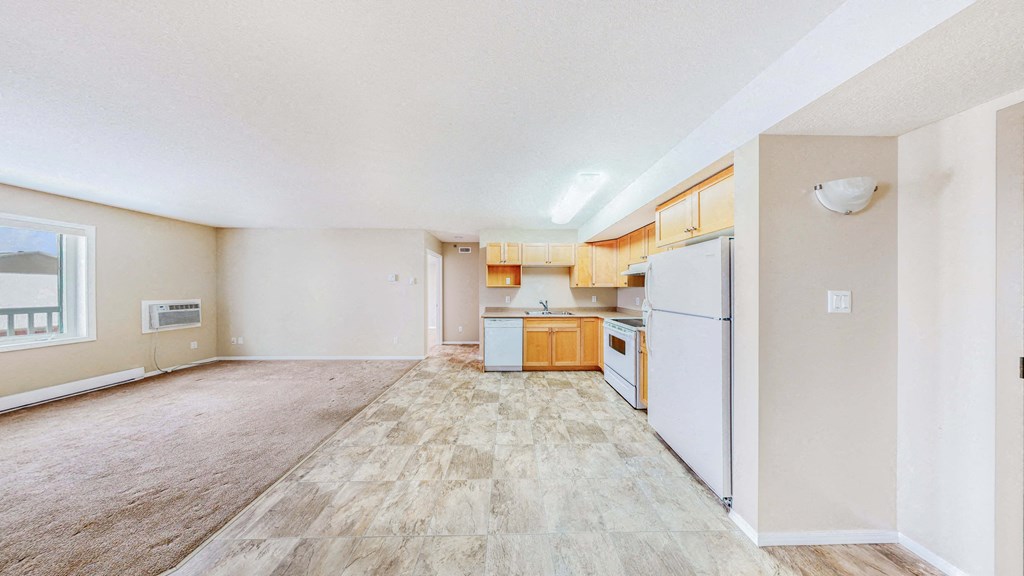 a spacious kitchen with white appliances and wooden floors