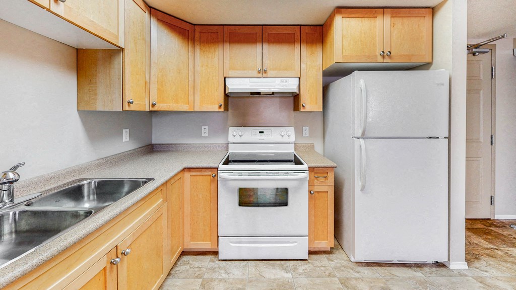 a kitchen with white appliances and wooden cabinets