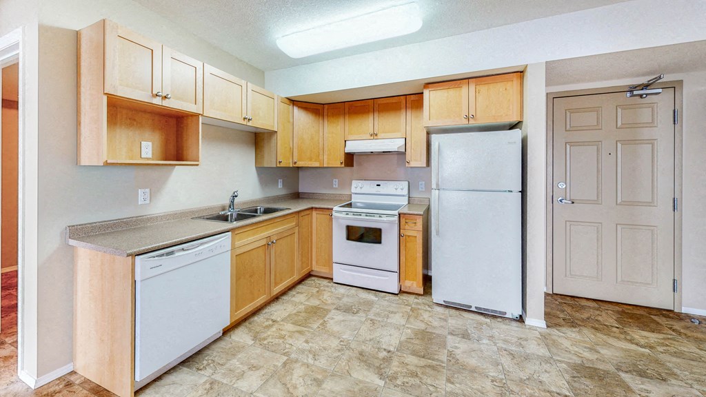 a kitchen with white appliances and wooden cabinets