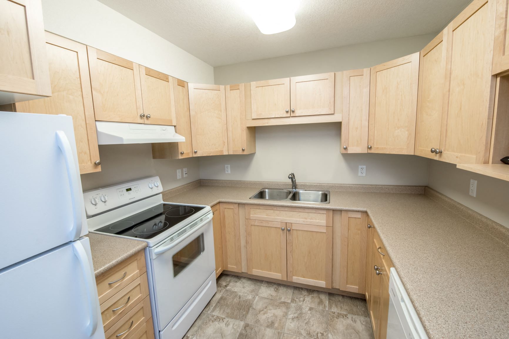 a kitchen with white appliances and wooden cabinets