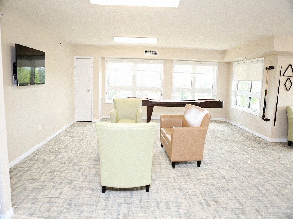 an empty living room with chairs and a pool table