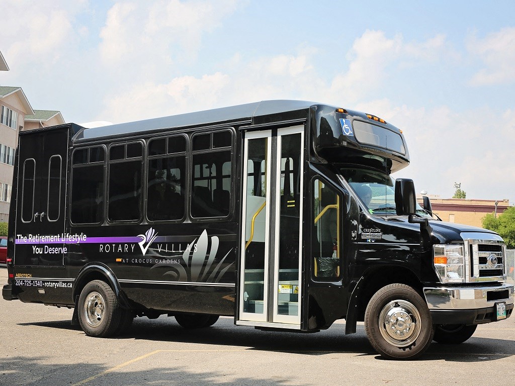 a black bus is parked in a parking lot