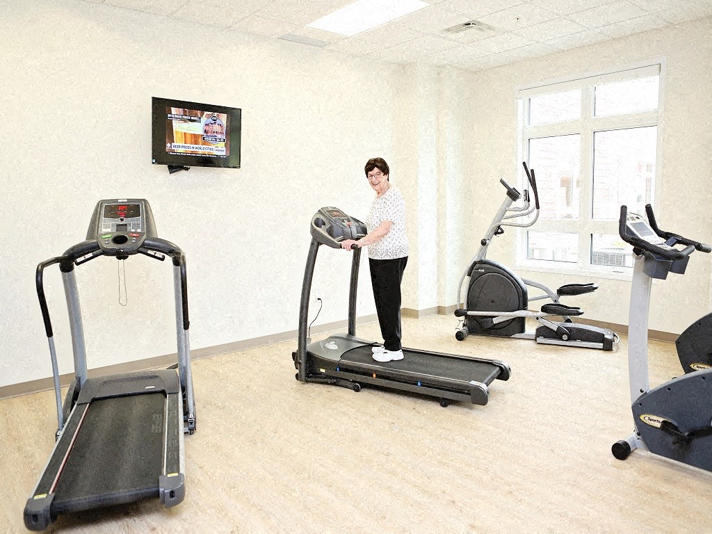 a woman is standing on a treadmill in a gym