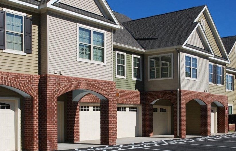 a brick house with white garage doors