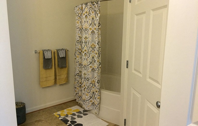a bathroom with a shower curtain and a white door