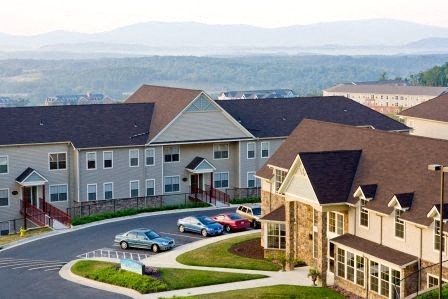 a neighborhood with houses and cars parked on a street