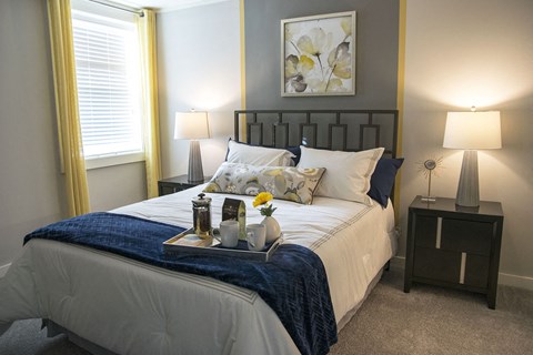 a bedroom with a bed and a tray with flowers on it