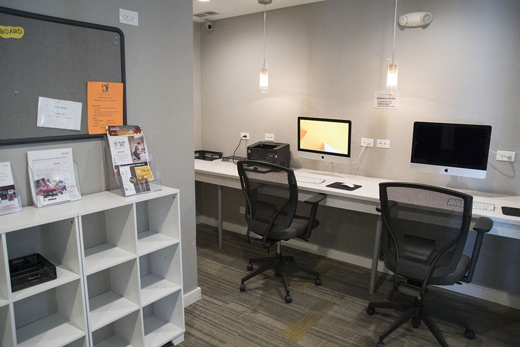 an office with two desks and two chairs and a monitor
