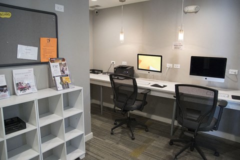 an office with two desks and two chairs and a monitor