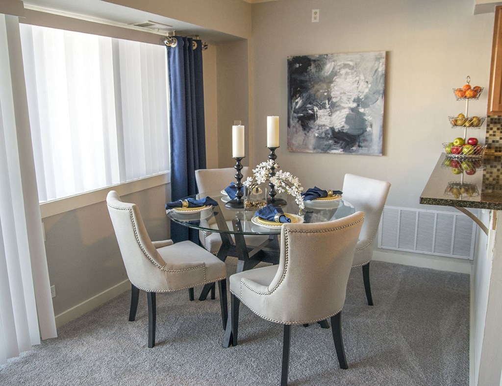 a dining room with a glass table and chairs