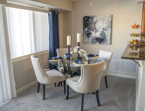 a dining room with a glass table and chairs