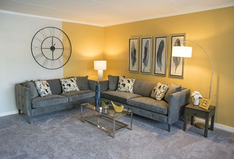 a living room with couches and a glass table