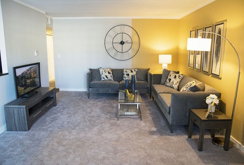 a living room with a couch and a clock on the wall