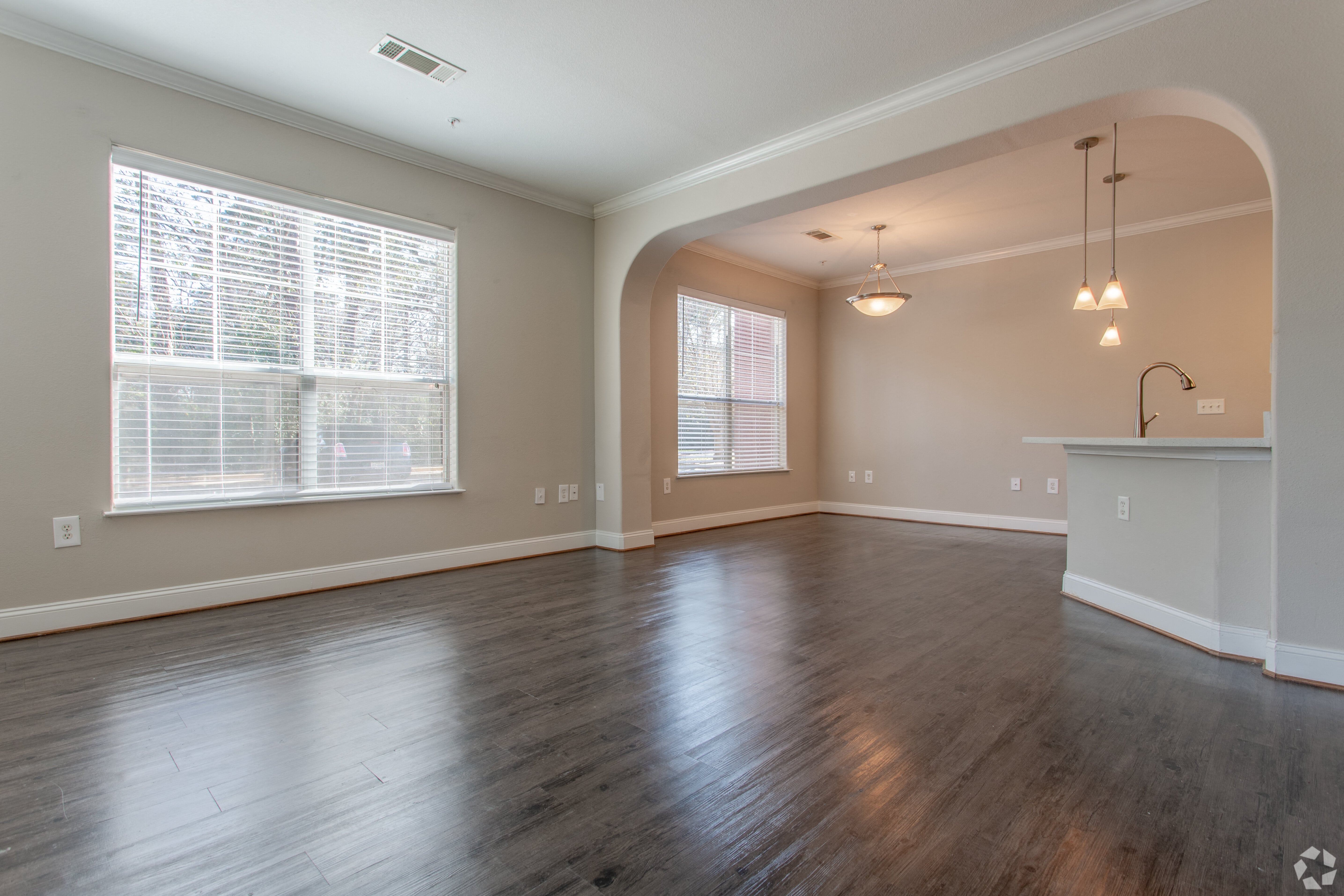 an empty living room with wood floors and a large window