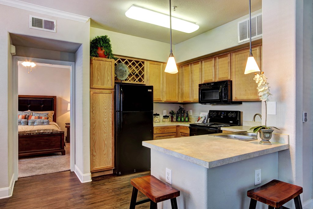 a kitchen with a island and a black refrigerator