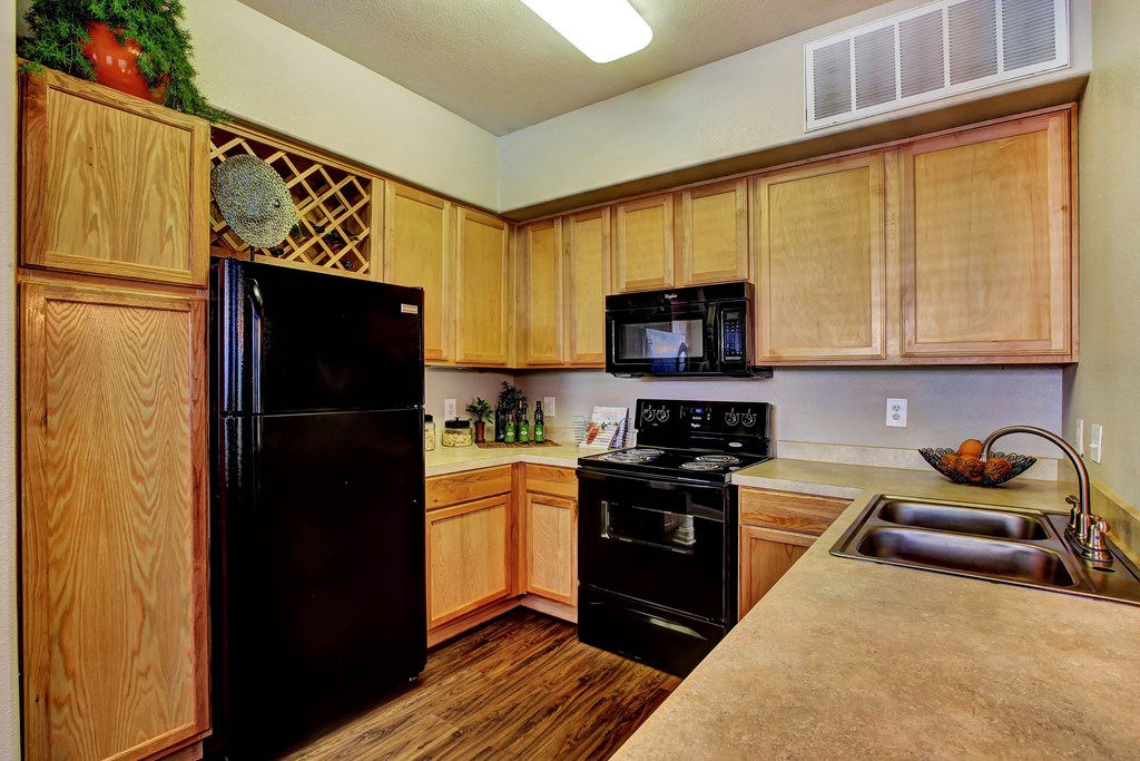 a kitchen with black appliances and wooden cabinets