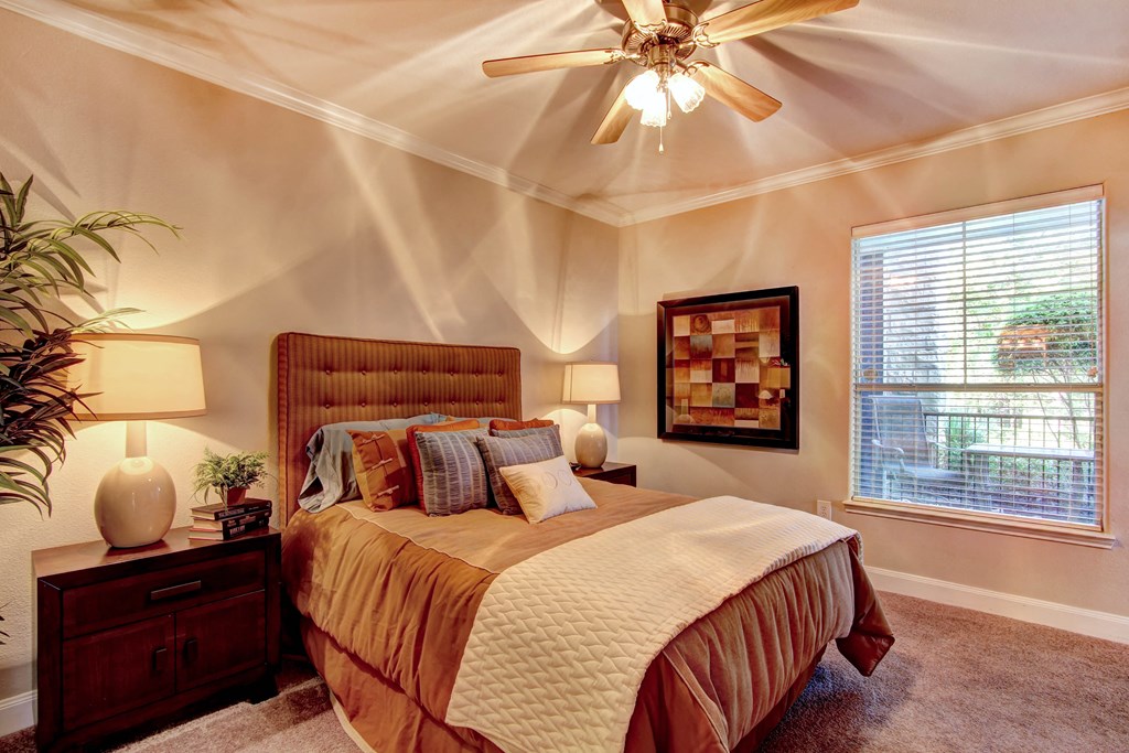 a bedroom with a bed and a ceiling fan