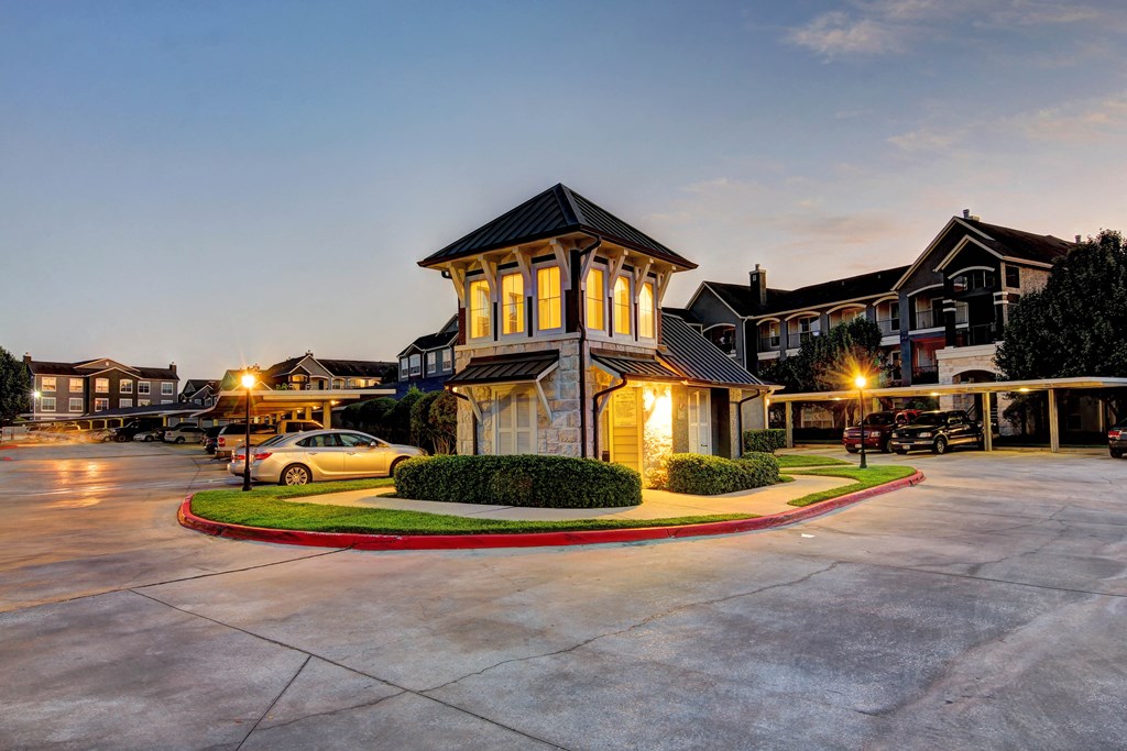 an empty parking lot at night with apartments in the background