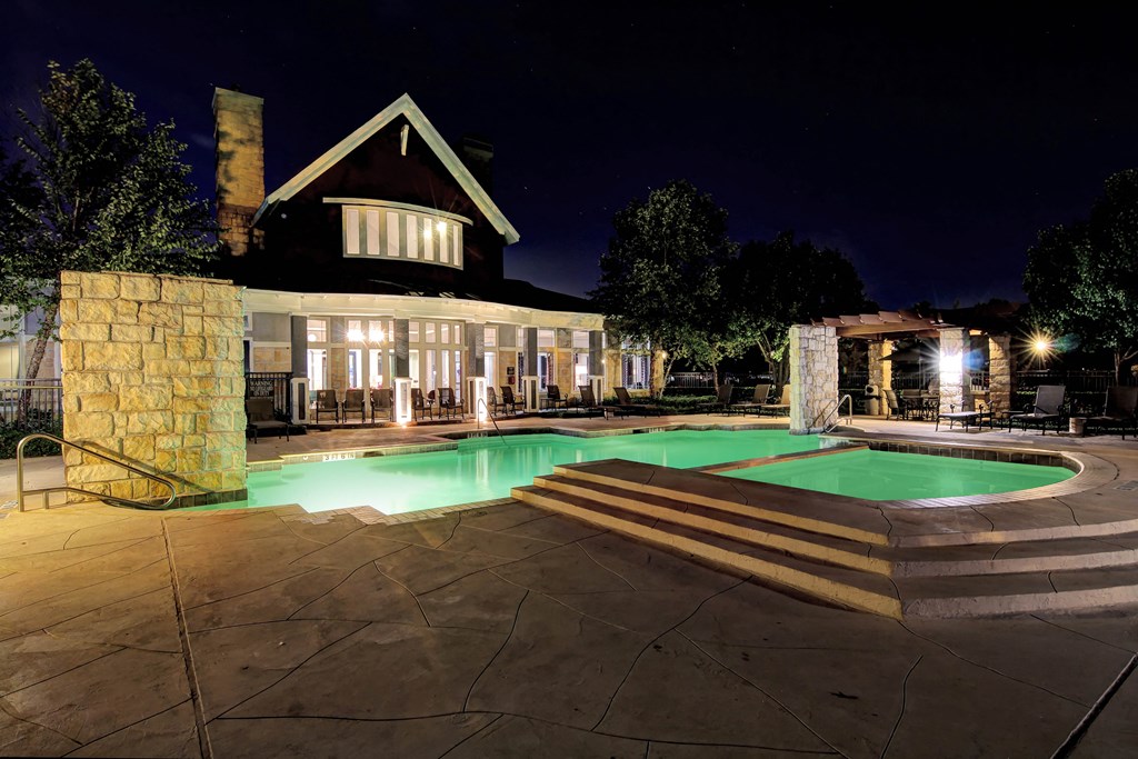 a swimming pool in front of a house at night
