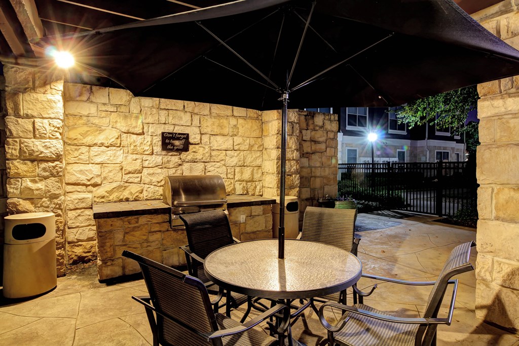 a patio with a table and chairs under an umbrella