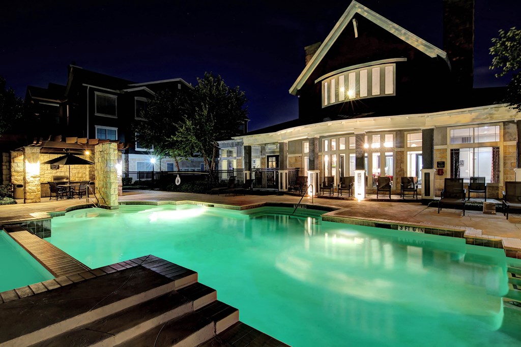 a swimming pool in front of a house at night