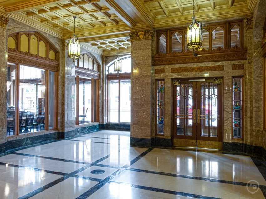 the lobby of a building with windows and a shiny floor