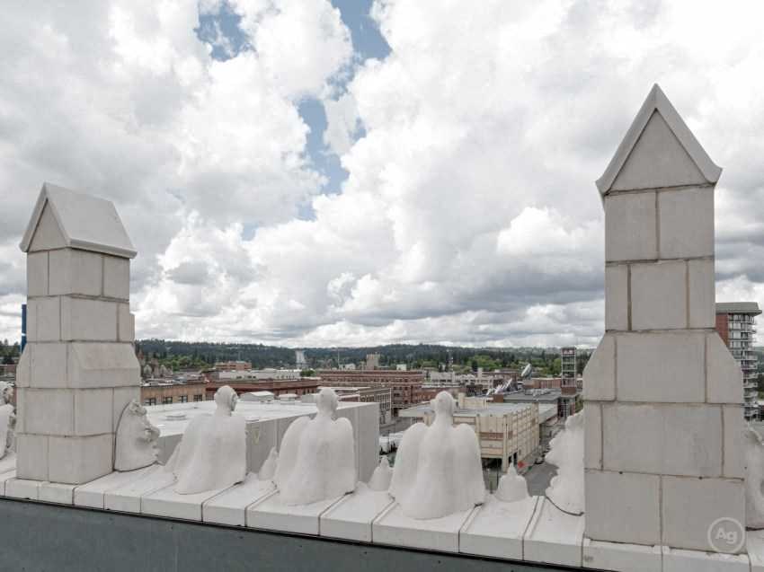 a group of white statues on the roof of a building