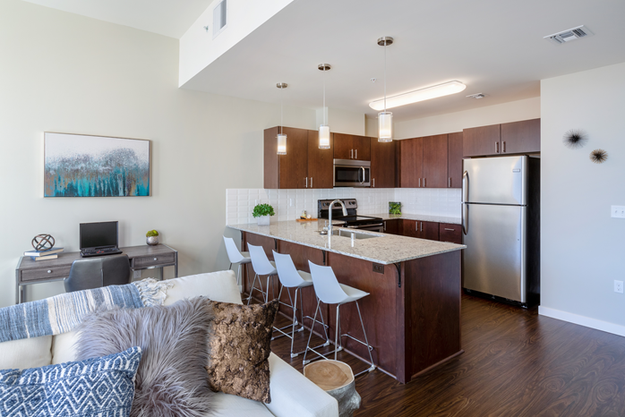a kitchen and living room with a large island and stainless steel appliances