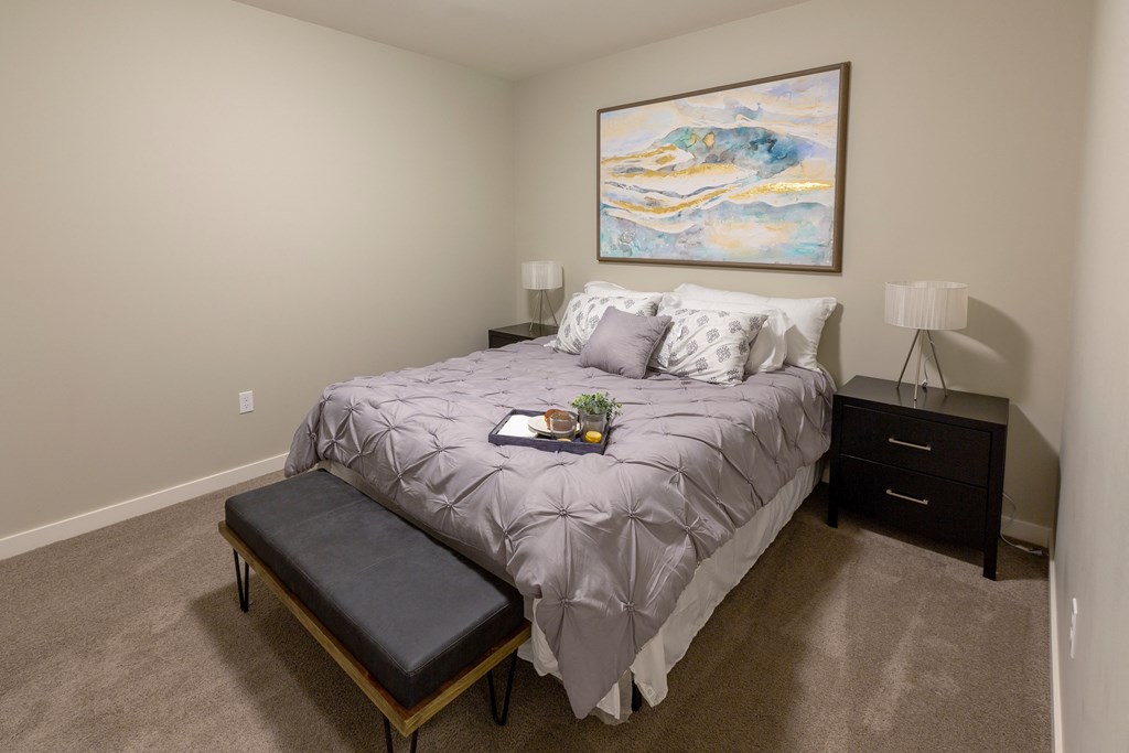 a bedroom with a large bed and a painting on the wall