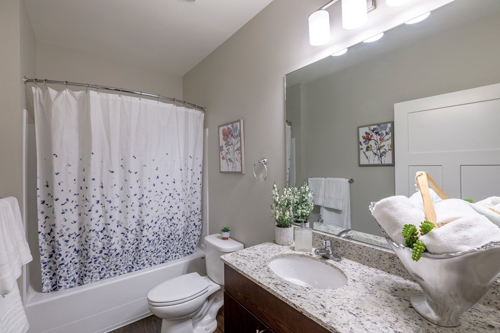 a bathroom with a sink toilet and shower and a mirror