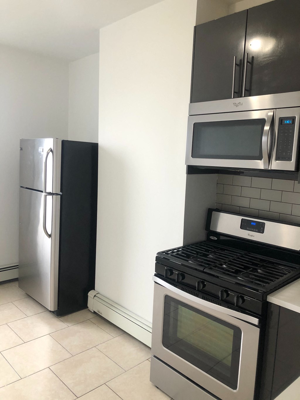 an empty kitchen with a stove and a refrigerator