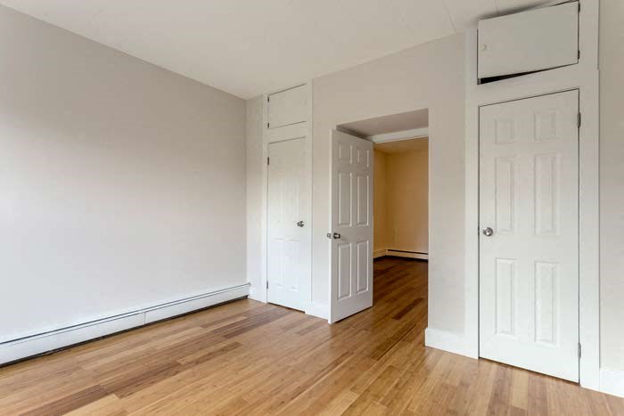 an empty room with white walls and a wooden floor