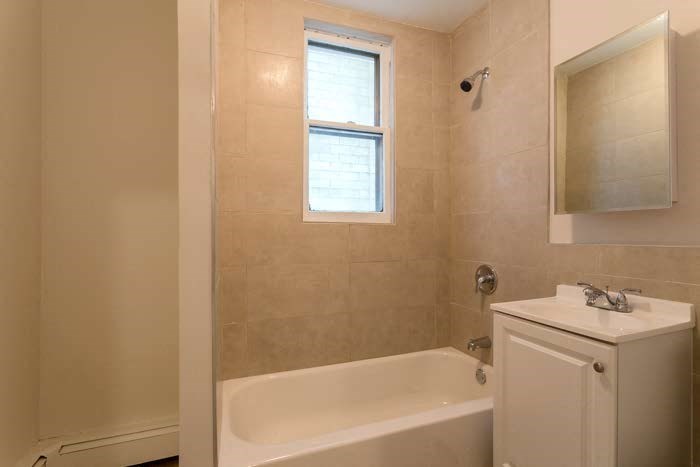 a bathroom with a tub and a sink and a window