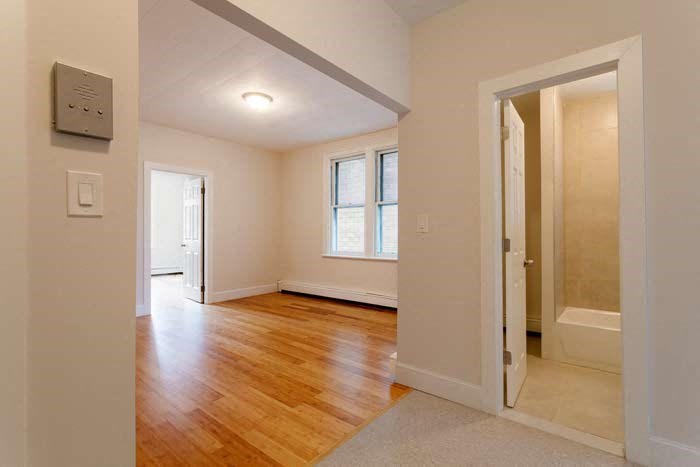 an empty room with a wood floor and a door