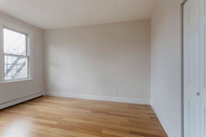 an empty room with a wooden floor and a window