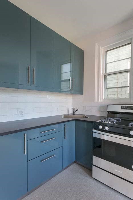 a kitchen with blue cabinets and a stove and a sink