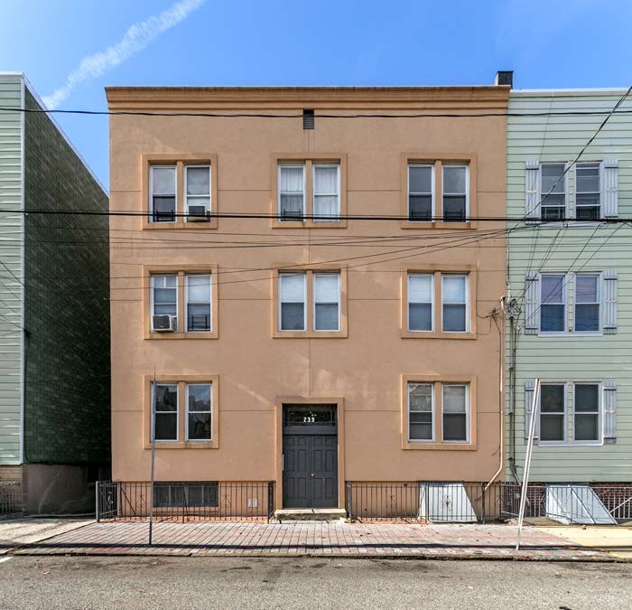 a brown building with a black door and