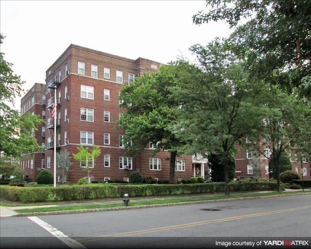 A red brick building with trees in front.