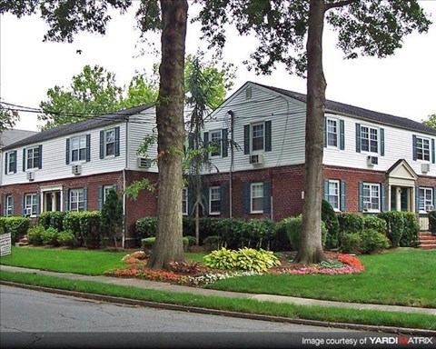 A white and red house with a green lawn in front.