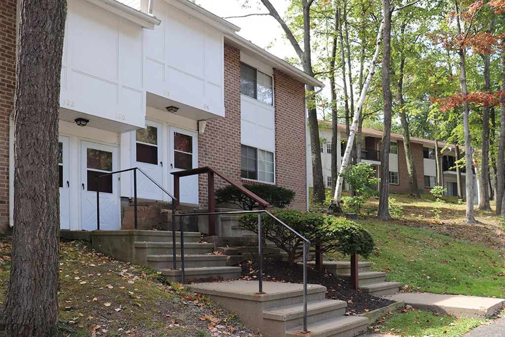 a building with stairs and trees in front of it
