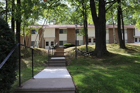 a building with stairs and trees in front of it