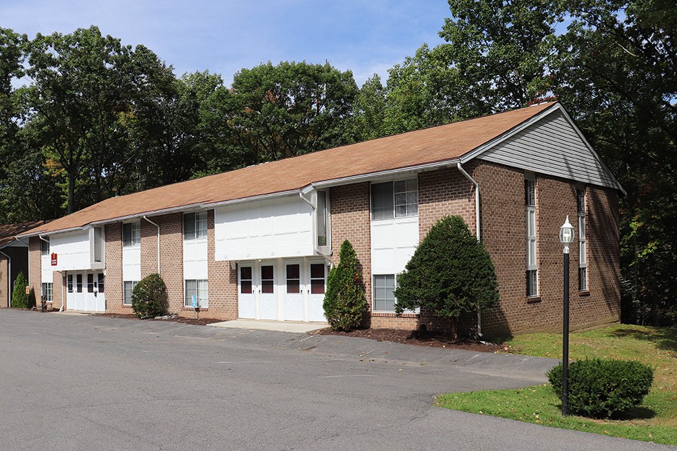 a brick building with white doors and a parking lot