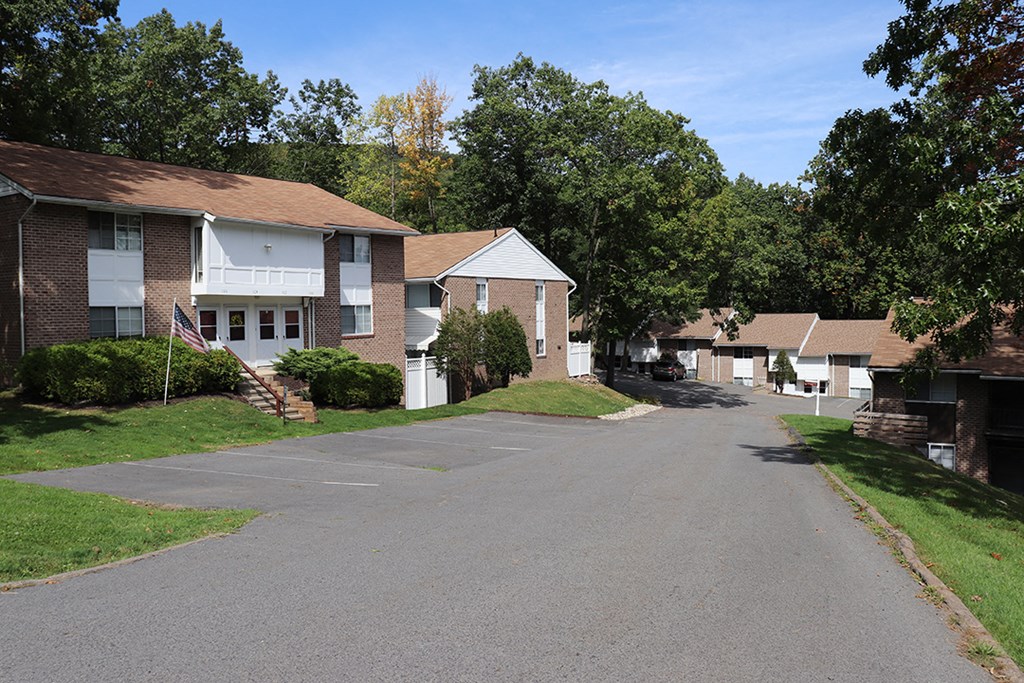 an empty street in a neighborhood with houses and trees