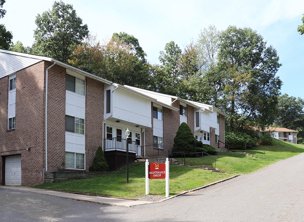 an apartment building with a red and white sign in front of it