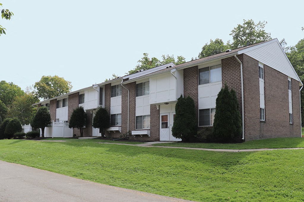 an apartment building with a green lawn in front of it