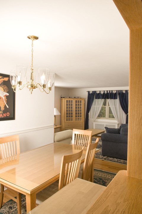 A dining room with a wooden table and chairs.