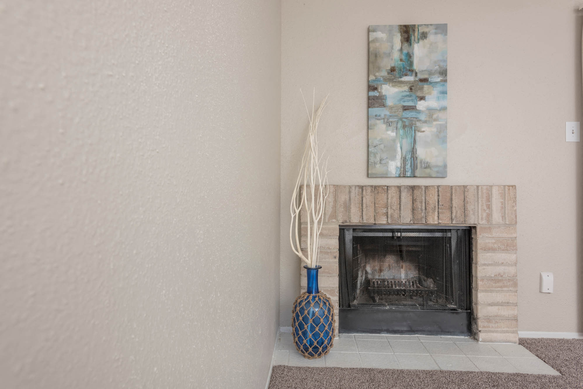 a living room with a fireplace and a painting on the wall