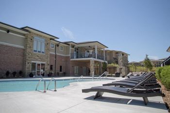 Resort style swimming pool with sun tanning loungers at The Villas of Omaha at Butler Ridge in Omaha, Nebraska